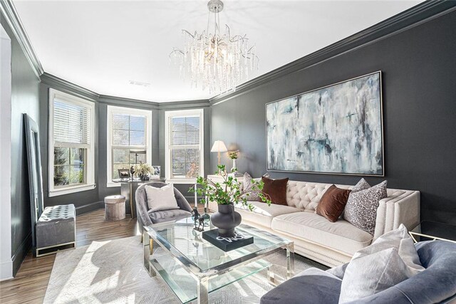 living room with a chandelier, crown molding, and wood-type flooring