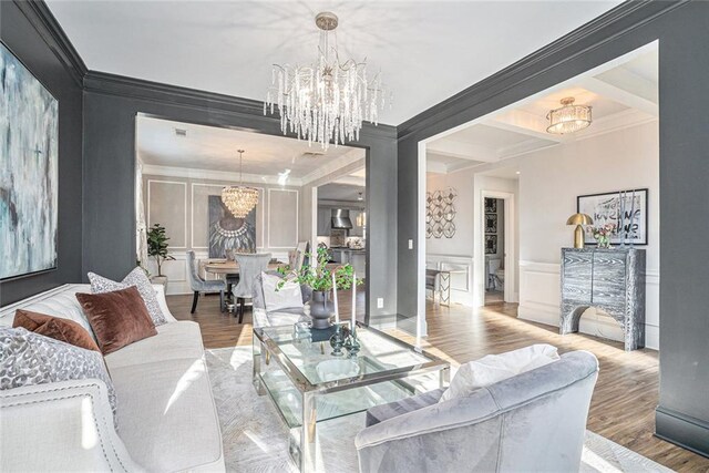 living room with wood-type flooring, beam ceiling, crown molding, and a notable chandelier