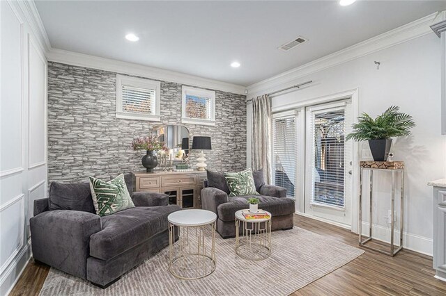 sitting room with hardwood / wood-style floors and crown molding