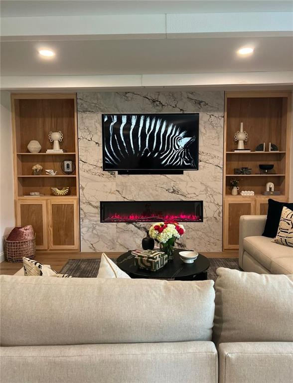 living room with a fireplace, hardwood / wood-style floors, and built in features