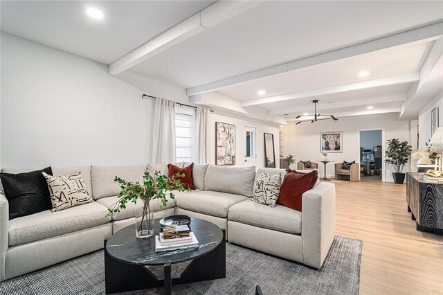 living room with beam ceiling and light hardwood / wood-style floors