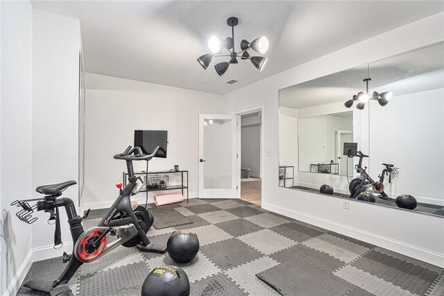 exercise area featuring french doors and a notable chandelier