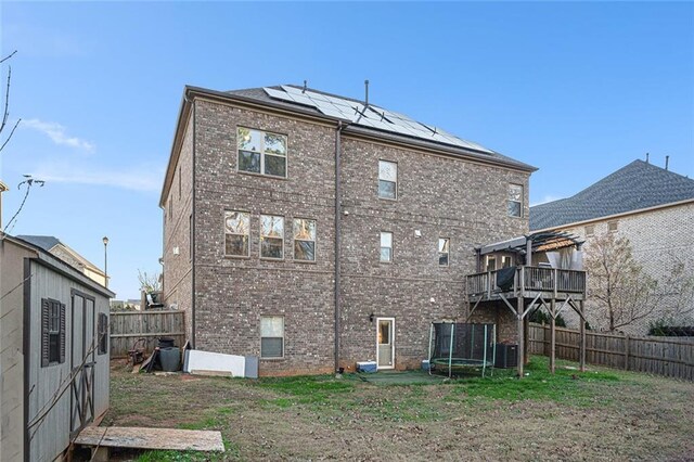 back of property featuring solar panels and central air condition unit