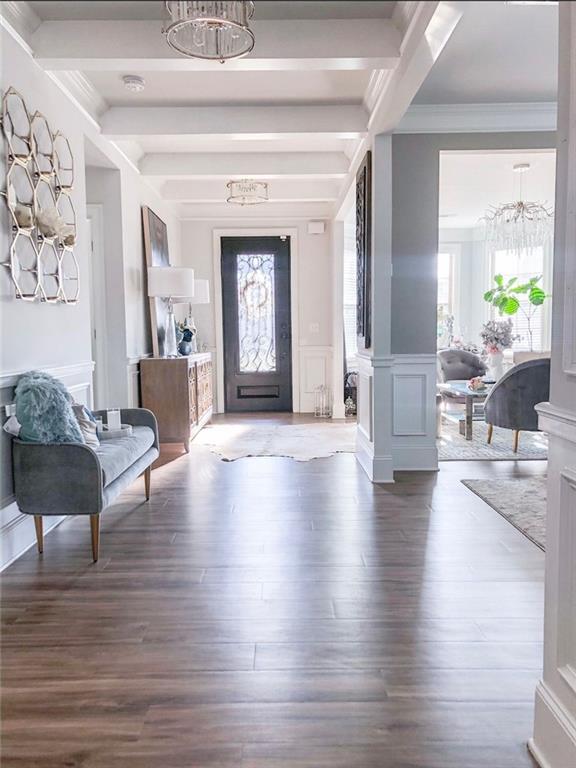 foyer featuring beamed ceiling, hardwood / wood-style flooring, and ornate columns