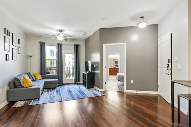 living room featuring ceiling fan and dark hardwood / wood-style flooring