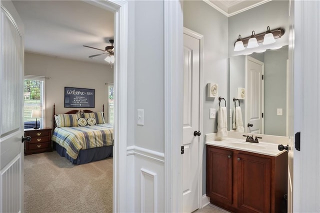 bathroom with ceiling fan, ornamental molding, and vanity
