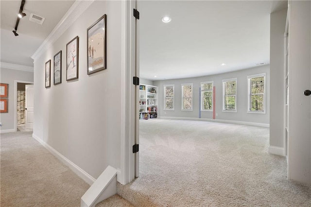 hallway with carpet, crown molding, rail lighting, baseboards, and recessed lighting