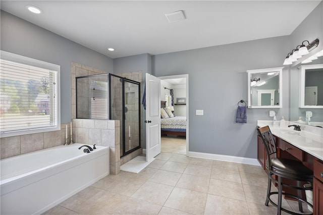 ensuite bathroom featuring a garden tub, a shower stall, tile patterned flooring, vanity, and baseboards