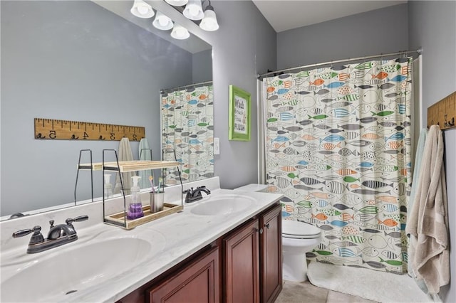 full bathroom featuring double vanity and toilet