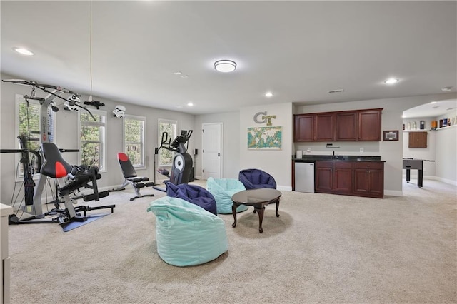 exercise room with light carpet, recessed lighting, baseboards, and bar