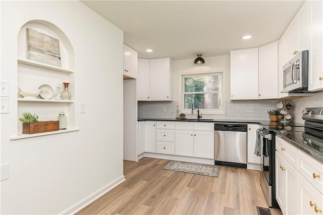 kitchen with sink, light hardwood / wood-style floors, white cabinets, and appliances with stainless steel finishes