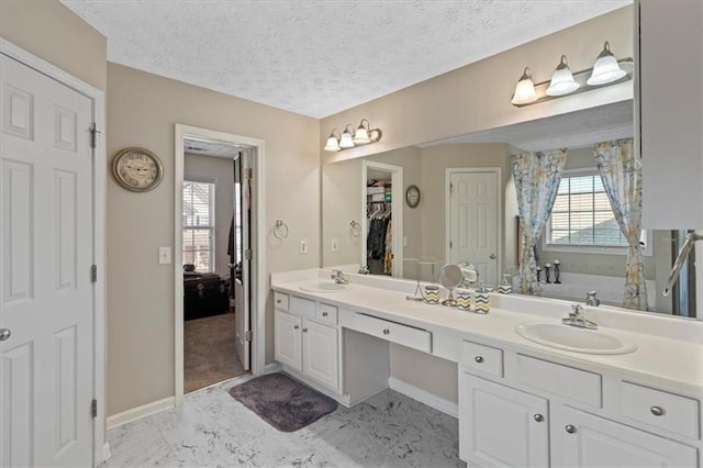 bathroom featuring vanity, a bathtub, and a textured ceiling