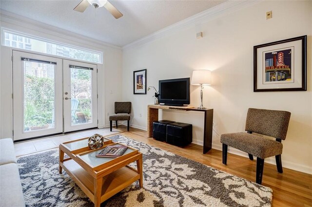 living room with ceiling fan, a healthy amount of sunlight, ornamental molding, and light wood-type flooring