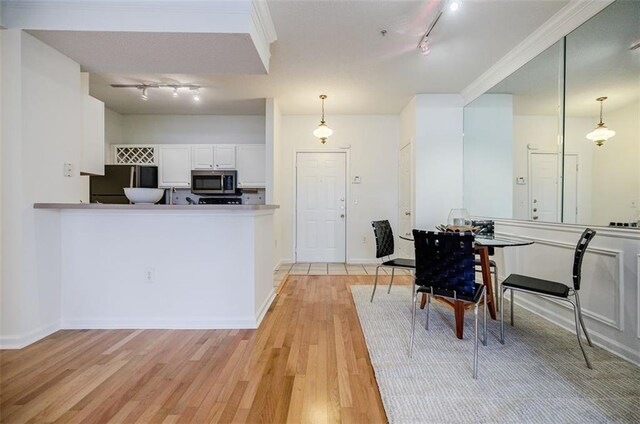 kitchen featuring white cabinetry, light wood-type flooring, track lighting, and refrigerator