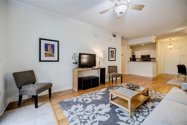 living room with light wood-type flooring, visible vents, and ornamental molding