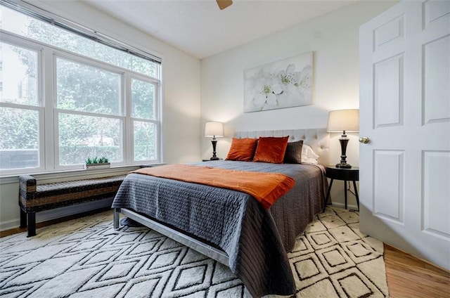 bedroom featuring light wood-type flooring, baseboards, and a ceiling fan