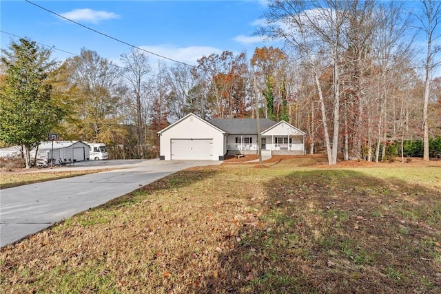 view of front of property featuring a garage, covered porch, driveway, and a front lawn