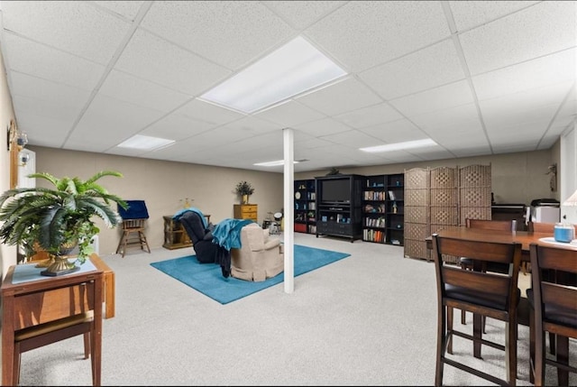 interior space with a drop ceiling and carpet flooring