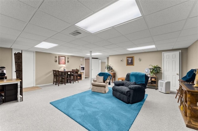 living room with carpet floors, a paneled ceiling, and visible vents