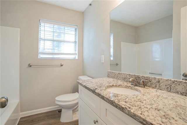 bathroom with hardwood / wood-style floors, vanity, and toilet