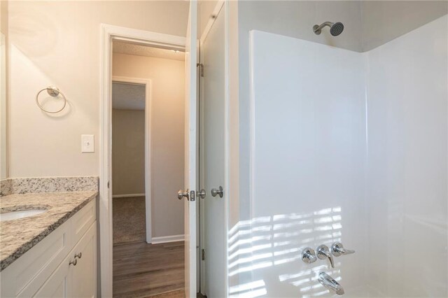 bathroom with separate shower and tub, hardwood / wood-style floors, and vanity