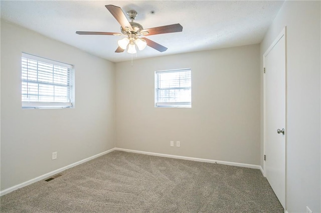 carpeted spare room featuring ceiling fan