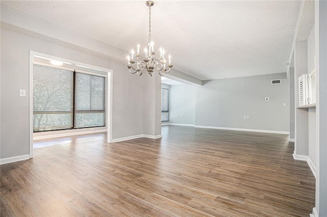 1800 Clairmont Lk Unit 412, Decatur, GA 30033 - unfurnished living room with a chandelier, wood finished floors, a textured ceiling, and baseboards