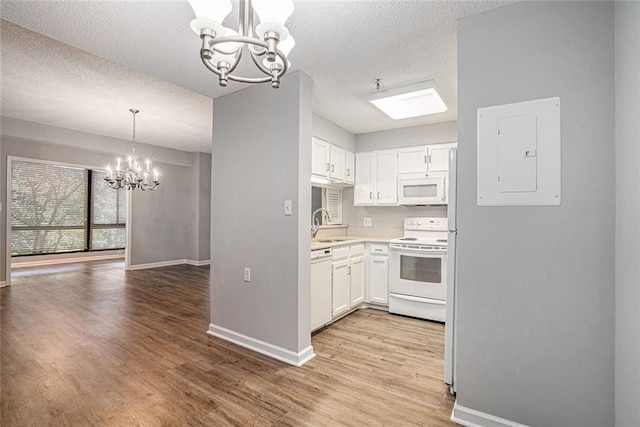 1800 Clairmont Lk Unit 412, Decatur, GA 30033 - kitchen with a chandelier, white appliances, electric panel, baseboards, and a textured ceiling