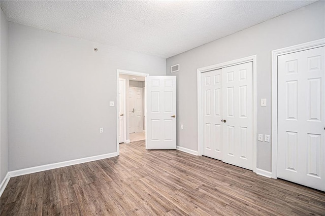 1800 Clairmont Lk Unit 412, Decatur, GA 30033 - unfurnished bedroom with wood finished floors, baseboards, and a textured ceiling