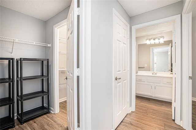 1800 Clairmont Lk Unit 412, Decatur, GA 30033 - corridor with light wood finished floors, a textured ceiling, and a sink