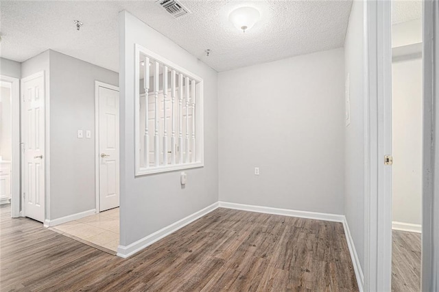 1800 Clairmont Lk Unit 412, Decatur, GA 30033 - empty room with wood finished floors, a textured ceiling, baseboards, and fire sprinkler in ceiling