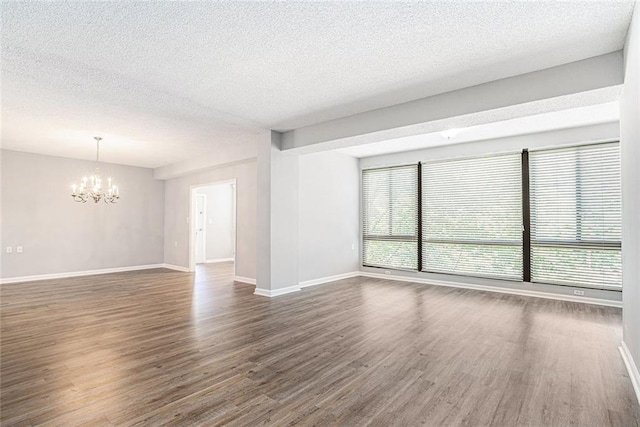 1800 Clairmont Lk Unit 412, Decatur, GA 30033 - unfurnished room featuring a chandelier, dark wood-style flooring, baseboards, and a textured ceiling