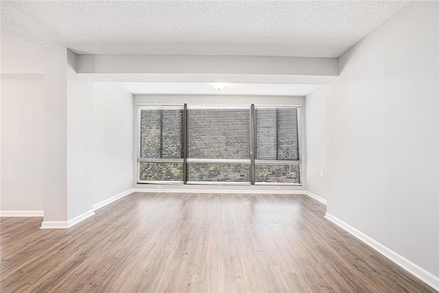 1800 Clairmont Lk Unit 412, Decatur, GA 30033 - unfurnished room with healthy amount of natural light, wood finished floors, a textured ceiling, and baseboards