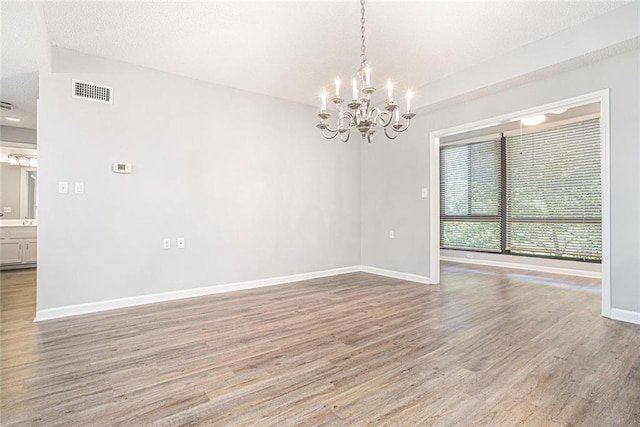 1800 Clairmont Lk Unit 412, Decatur, GA 30033 - spare room featuring a chandelier, baseboards, and light wood-style floors