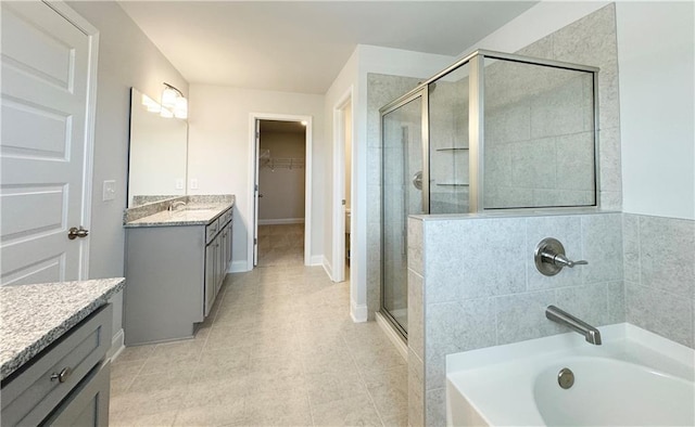 3817 Billabong Trl Unit 104, Gainesville, GA 30506 - bathroom featuring vanity, tile patterned flooring, a bathtub, a shower stall, and a walk in closet