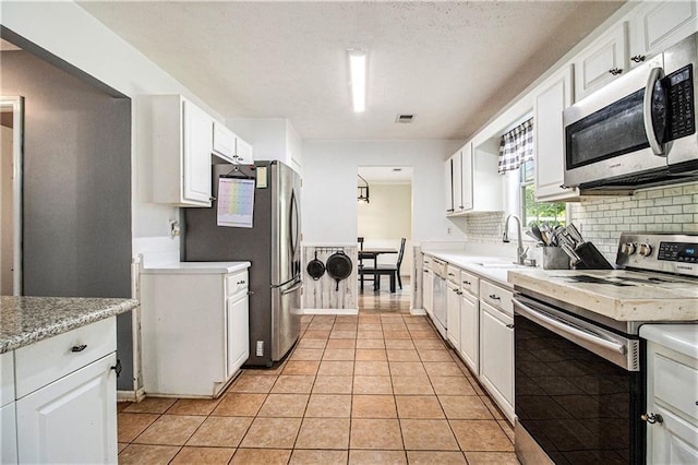 7341 Raleigh Way, Bethlehem, GA 30620 - kitchen featuring stainless steel appliances, a sink, white cabinets, and tasteful backsplash