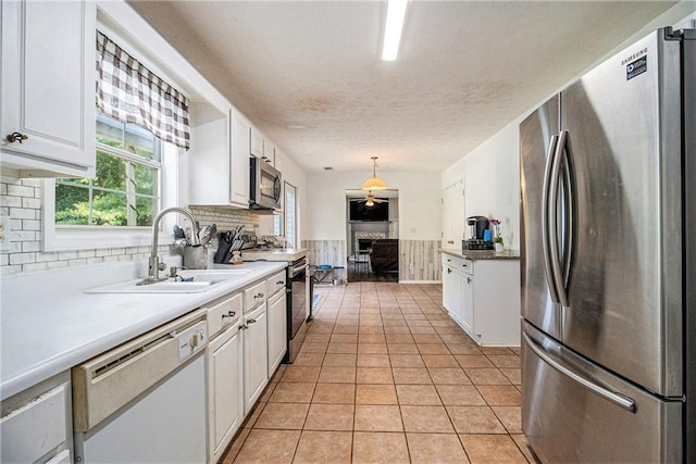 7341 Raleigh Way, Bethlehem, GA 30620 - kitchen featuring appliances with stainless steel finishes, a sink, a textured ceiling, white cabinetry, and tasteful backsplash