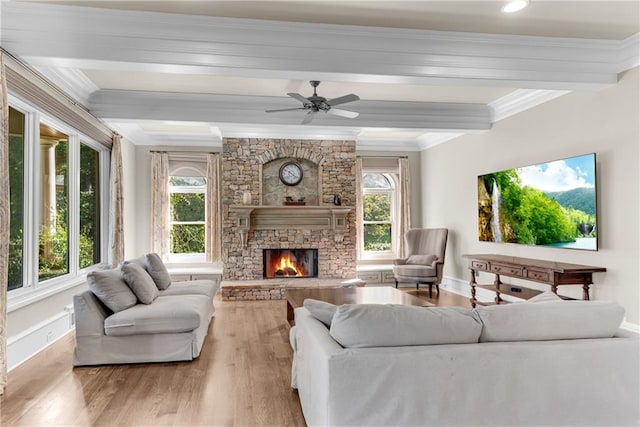 living room featuring a fireplace, light wood-type flooring, a healthy amount of sunlight, and ceiling fan