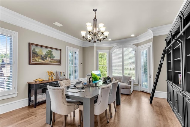 dining space featuring baseboards, ornamental molding, an inviting chandelier, and light wood-style floors