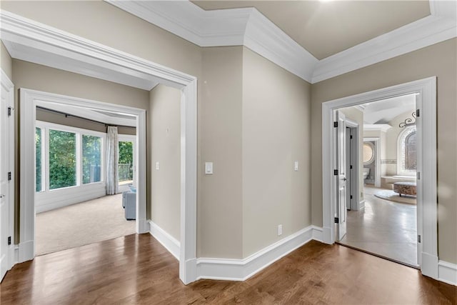 hallway with ornamental molding, dark wood-style flooring, and baseboards