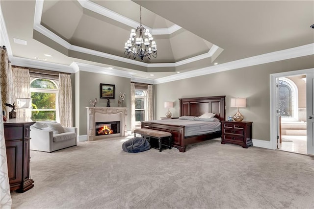 carpeted bedroom featuring a fireplace, ornamental molding, a tray ceiling, and a notable chandelier