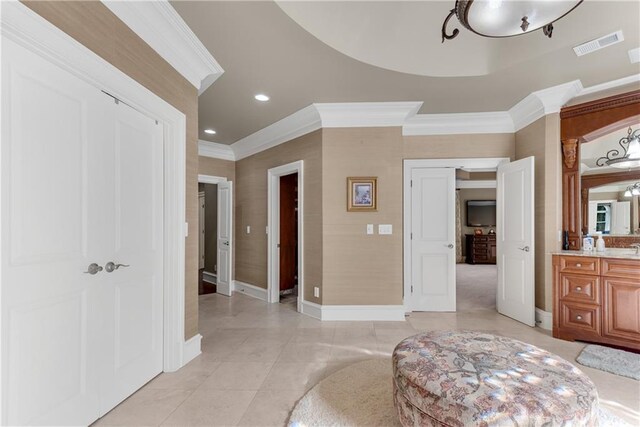 tiled bedroom featuring ensuite bathroom and crown molding