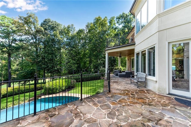 view of patio / terrace with an outdoor hangout area, a balcony, a ceiling fan, and a fenced in pool