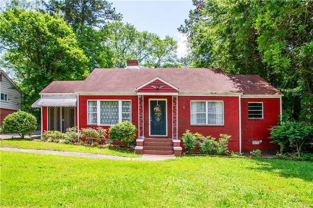 3020 Washington Rd, East Point, GA 30344 - view of front of house featuring a front lawn, entry steps, a chimney, brick siding, and a shingled roof