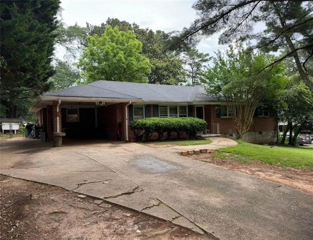 ranch-style house with concrete driveway, an attached carport, and brick siding