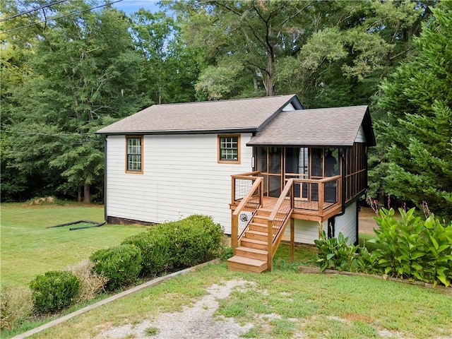 view of front of home with a sunroom and a front yard