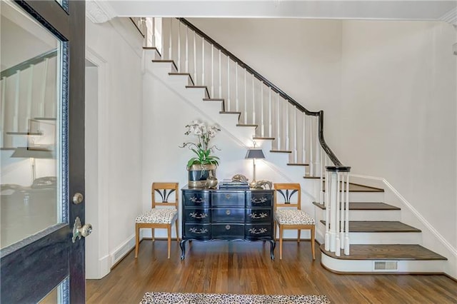 entryway with wood finished floors, stairs, and baseboards