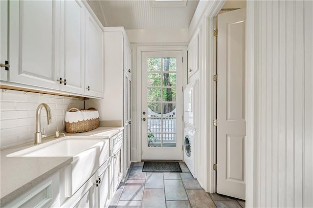mudroom with stacked washer / dryer, a sink, and light tile patterned flooring