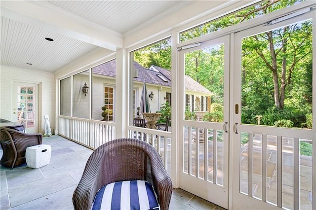 sunroom / solarium with plenty of natural light and stone tile flooring
