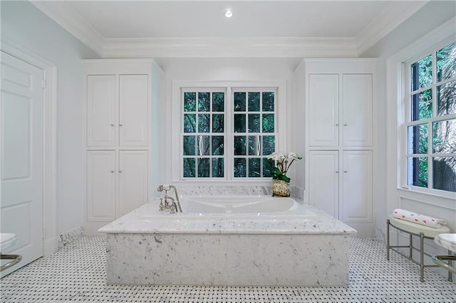 bathroom featuring a garden tub, crown molding, and a closet